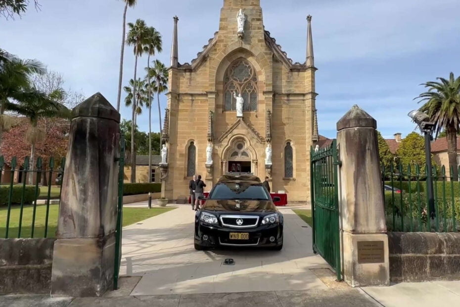 A black hearse parked outside a church